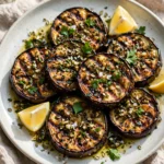Grilled eggplant with garlic herb marinade on a platter