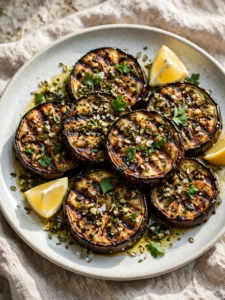 Grilled eggplant with garlic herb marinade on a platter