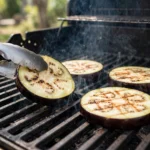 Eggplant rounds grilling over heat