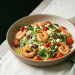 Keto Mediterranean shrimp zoodles in a skillet with cherry tomatoes, olives, feta and lemon