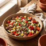 Keto Mediterranean ground beef skillet with zucchini, peppers, tomatoes, and feta in a rustic skillet