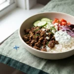 Greek ground beef gyro bowl with spiced beef, rice, vegetables, feta, and tzatziki