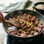 Ground turkey browning with oregano, garlic and lemon zest for a Mediterranean turkey bowl