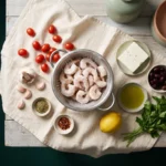 Frozen raw shrimp in a colander with cherry tomatoes, garlic, feta, olives, lemon and parsley laid out