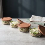 Portions of keto philly cheesesteak casserole boxed in round glass meal prep containers