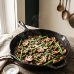 Keto ground beef mushroom skillet in a cast iron pan with green beans and Parmesan
