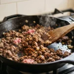Ground beef browning in a skillet for keto ground beef cauliflower casserole