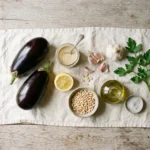 Raw ingredients for roasted eggplant with lemon tahini: eggplants, tahini, lemon, garlic, pine nuts