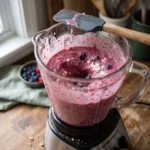 Cottage cheese berry protein smoothie blending in a glass jar with berries mid-swirl
