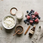 Raw ingredients for a cottage cheese berry protein smoothie: cheese, milk, berries, and chia