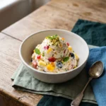 Tutti frutti frozen yogurt scooped with mango berries pineapple and pistachios