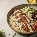 Keto Mediterranean cauliflower rice bowl with spiced chicken, feta, olives, and lemon-tahini yogurt