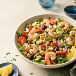 No cook Mediterranean shrimp salad with chilled shrimp, chickpeas, cucumber, tomatoes, olives, arugula, feta, and lemon