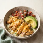 Keto chicken burrito bowl under 500 calories in a bowl with cauliflower rice, avocado, salsa, and melted cheese