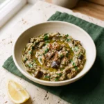 Greek eggplant dip melitzanosalata in a cream bowl with parsley