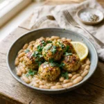 Mediterranean chicken meatballs with lemony white beans in a shallow bowl